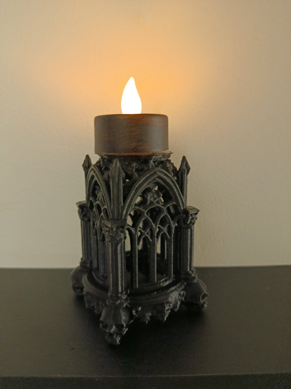Gothic Pillar Lantern with a candle on top sat on a black shelf